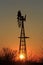 Colorful Kansas Sunset with a Windmill and tree silhouettes.