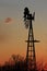 Colorful Kansas Sunset with a Windmill and tree silhouettes.