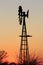 Colorful Kansas Sunset with a Windmill and tree silhouettes.