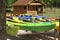 Colorful kayaks placed on racks against the background of a wooden house. Relaxing on the water. Water equipment rental.