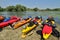 Colorful kayaks resting on riverbank