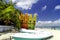 Colorful kayaks on the tropical white sandy seashore with cloudy blue sky background.