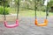 Colorful kids playground in public park, set of modern chain swings.