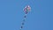 Colorful kite flying against a blue sky and sun