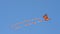 Colorful kite flying against a blue sky and sun