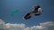 Colorful kite flying against a blue sky and sun