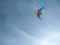 Colorful kite flying in the wind against clear blue sky with copy space. Close-up view of the striped rainbow kite flying in the