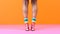 Colorful Leggings And Heels: Women\\\'s Legs Walking On A Pink Background