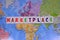 Colorful letters writing marketplace, world map background