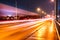 Colorful light traces from busy night traffic on the central bridge in Umea city, foggy autumn weather, Sweden