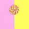 Colorful lollipop caramel on stick over pink yellow background t