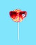 Colorful lollipop caramel on stick with sunglasses over blue