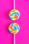 Colorful lollipops on pink background. Candy colored flat lay. Minimal concept for party and childhood.