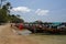 Colorful longtail boats and tourists sunbathing on white sands of a paradise Sai Nuan beach, Koh Ta, Thailand