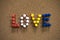 Colorful Love text written with thumbtacks on cork board for Valentine`s Day