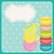 Colorful macaron cookies and teacup on blue background