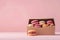 colorful macarons in the box on the pink table with copy space on the pink wall