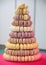 Colorful macarons on pyramid-shaped plastic stand on many visible levels