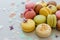 Colorful macarons on trendy pastel gray paper with lilac flowers