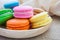 Colorful macarons on wooden plate