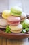 Colorful macaroons on brown plate