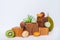 Colorful macaroons sweets on trendy wooden geometric stands or podiums with fresh kiwi fruit, pumpkin and greenery on a