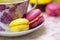 Colorful macaroons - yellow and pink - on plate with cup