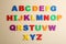 Colorful magnetic letters on beige, flat lay. Alphabetical order