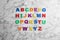 Colorful magnetic letters on white background, flat lay. Alphabetical order