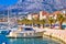 Colorful Makarska boats and waterfront under Biokovo mountain vi