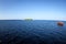 Colorful maldivian dhoni boat sits in open blue waters near a tropical island