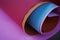 Colorful manila paper rolls background in pink, red, blue and orange colors.