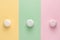 Colorful marshmallows on three different colors backgrounds yellow, green, pink