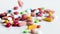 Colorful medical pills, capsules and tablets falling on white table