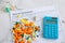 Colorful medicine pills on insurance paper bill and blue calculator. Health care cost concept