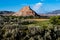 Colorful mesa and distant storm cloud above fields and ranches near Abiquiu, New Mexico