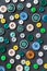 Colorful mixed sewing buttons on black background, flat lay