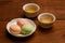 Colorful mochi rice cake on white plate and two porcelain cups w