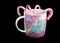 Colorful mug with picture of unicorn isolated on black background. Pink-and-white lollipops