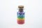 Colorful multicolor beads or tablets are poured into a glass bottle. A rainbow in a bottle. Magic pills. Macro