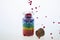 Colorful multicolor beads or tablets are poured into a glass bottle. A rainbow in a bottle. Magic pills. Macro