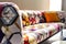 Colorful multicolored patchwork tufted sofa with orange pillow. Pop art home interior design of modern living room. Created with