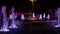 Colorful musical fountain at night, shimmering in different colors.