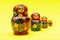 Colorful Nesting wooden Dolls isolated on bright yellow. National Russian souvenirs. Babushkas or Matryoshkas.