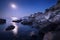 Colorful night landscape with full moon, lunar path and rocks in summer. Mountain landscape at the sea.