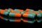 Colorful oblong pharmaceutical capsules on reflective surface, black background