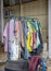 Colorful old clothes are hanging disorderly on iron railings near the cluttered things
