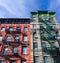 Colorful old historic apartment buildings with fire escapes in Manhattan New York City