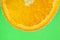 Colorful orange slice with bubbles on green background