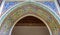 Colorful ornate arabesque plaster carvings above an archway in M